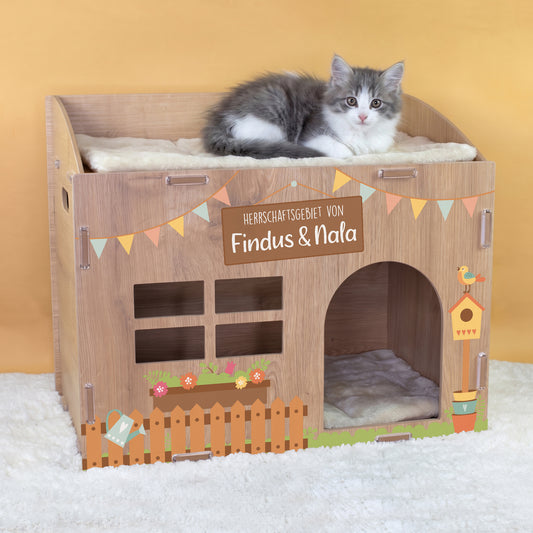 Katzenhaus in Eiche-Optik mit Wunschtext Herrschaftsgebiet von Findus und Nala und Katze auf dem Kissen
