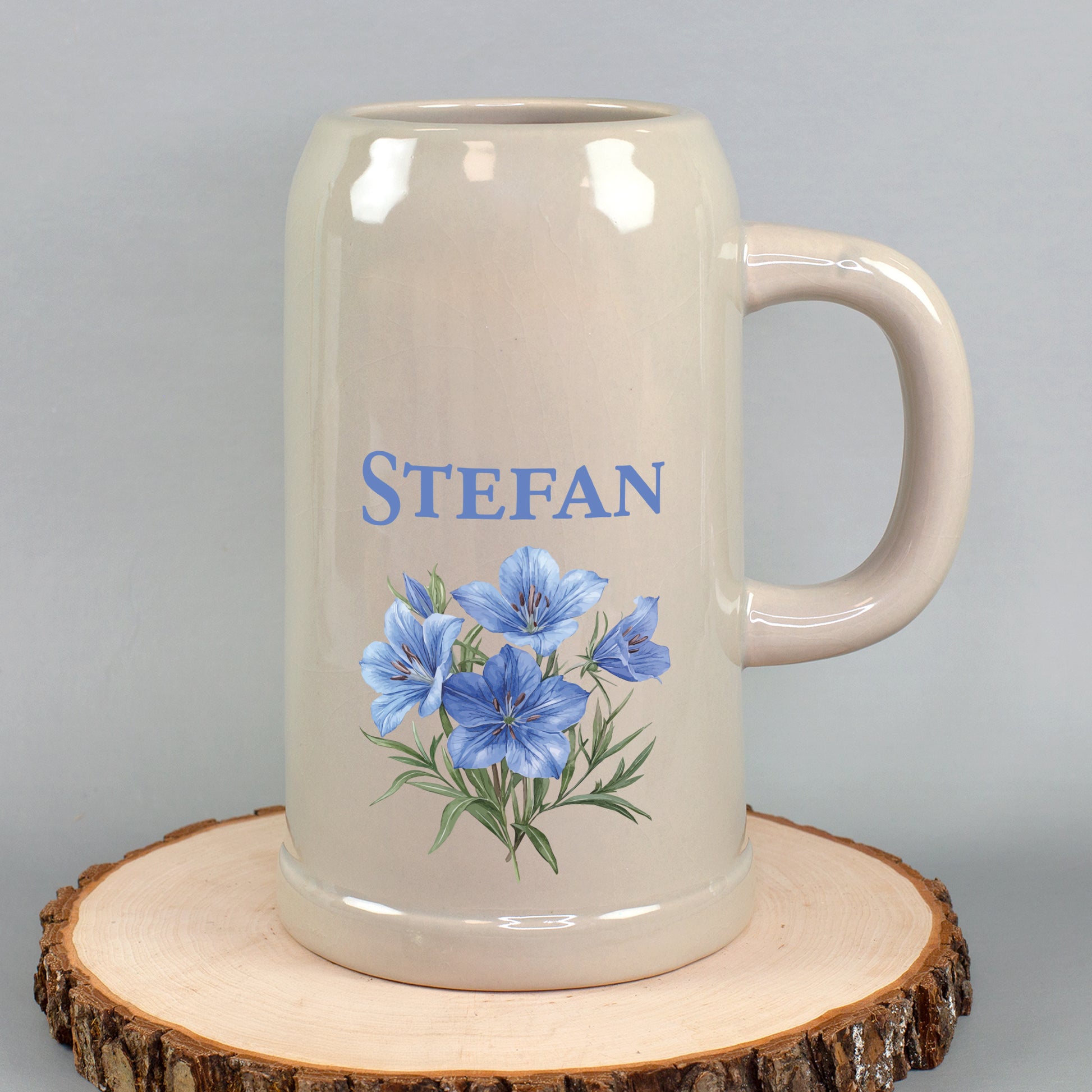 Großer Bierkrug mit Namen Stefan und blauem Enzianblumen-Motiv auf Holzscheibe