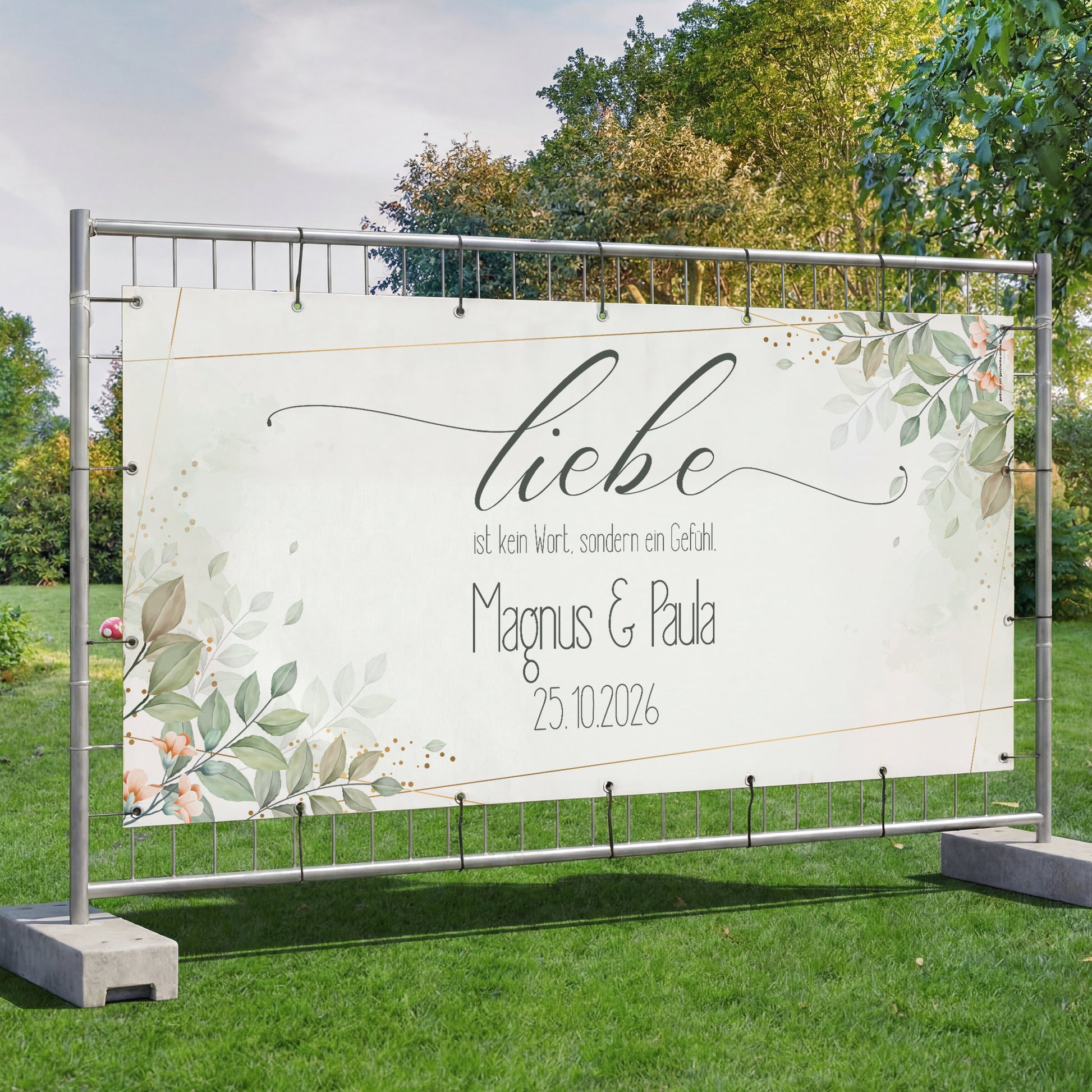 Großes Bauzaunbanner Hochzeit mit Blättermotiv, Namen und Datum auf freistehendem Zaun