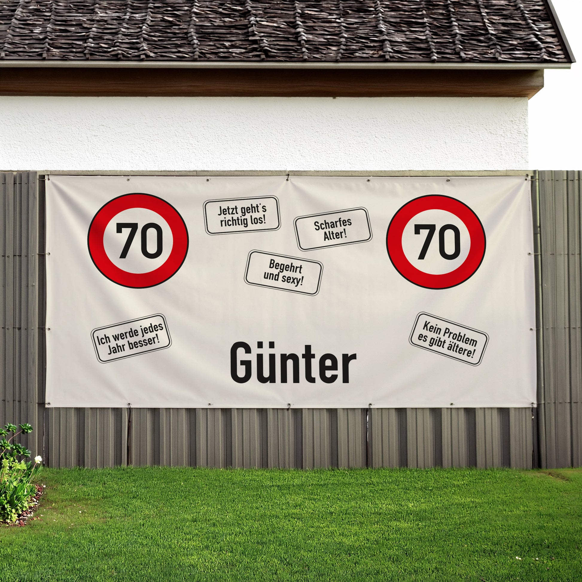 Großes Banner zum 70. Geburtstag mit Name Günter und roten Verkehrsschildern an Haus und Zaun