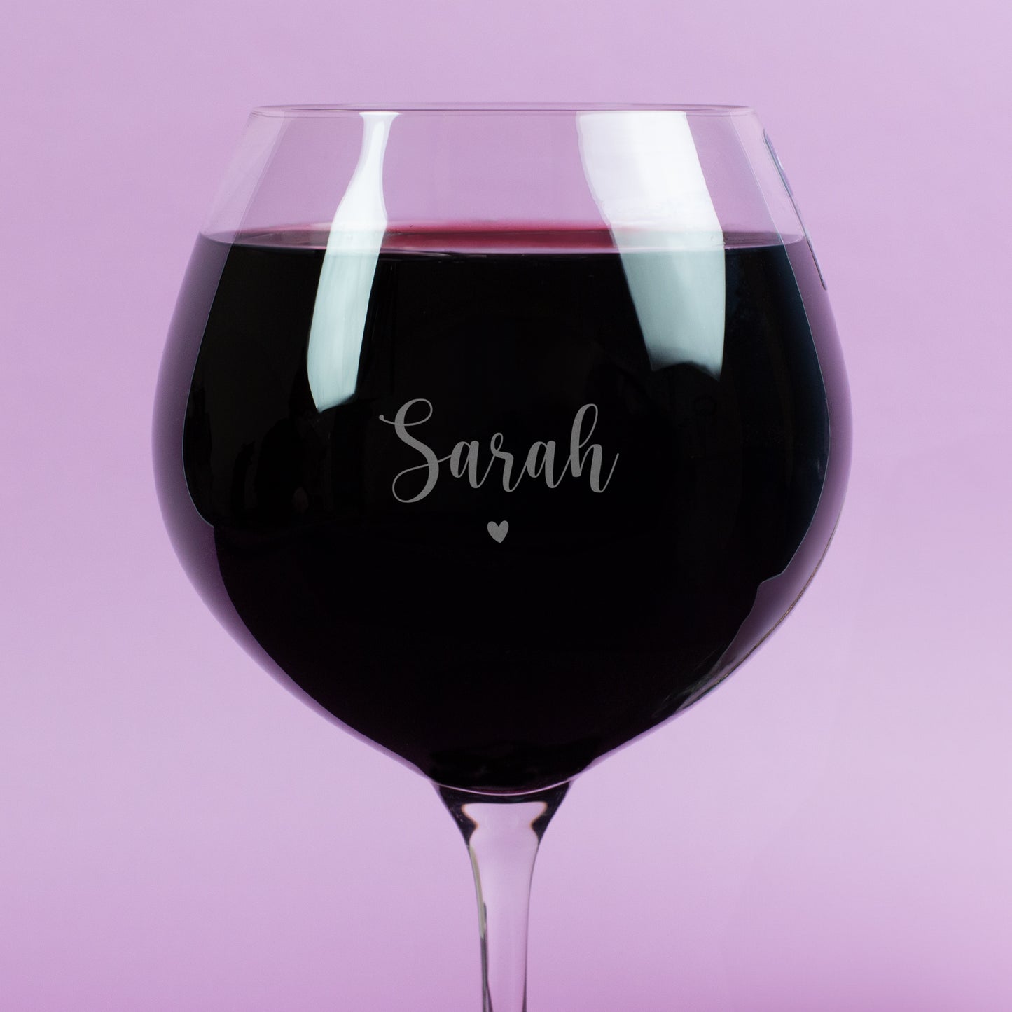 Detailansicht der Gravur auf Burgunderglas – Name „Sarah“ mit zartem Herzsymbol, feine Gravur auf klarem Glas, Rotwein betont Schriftzug, romantisches Design.