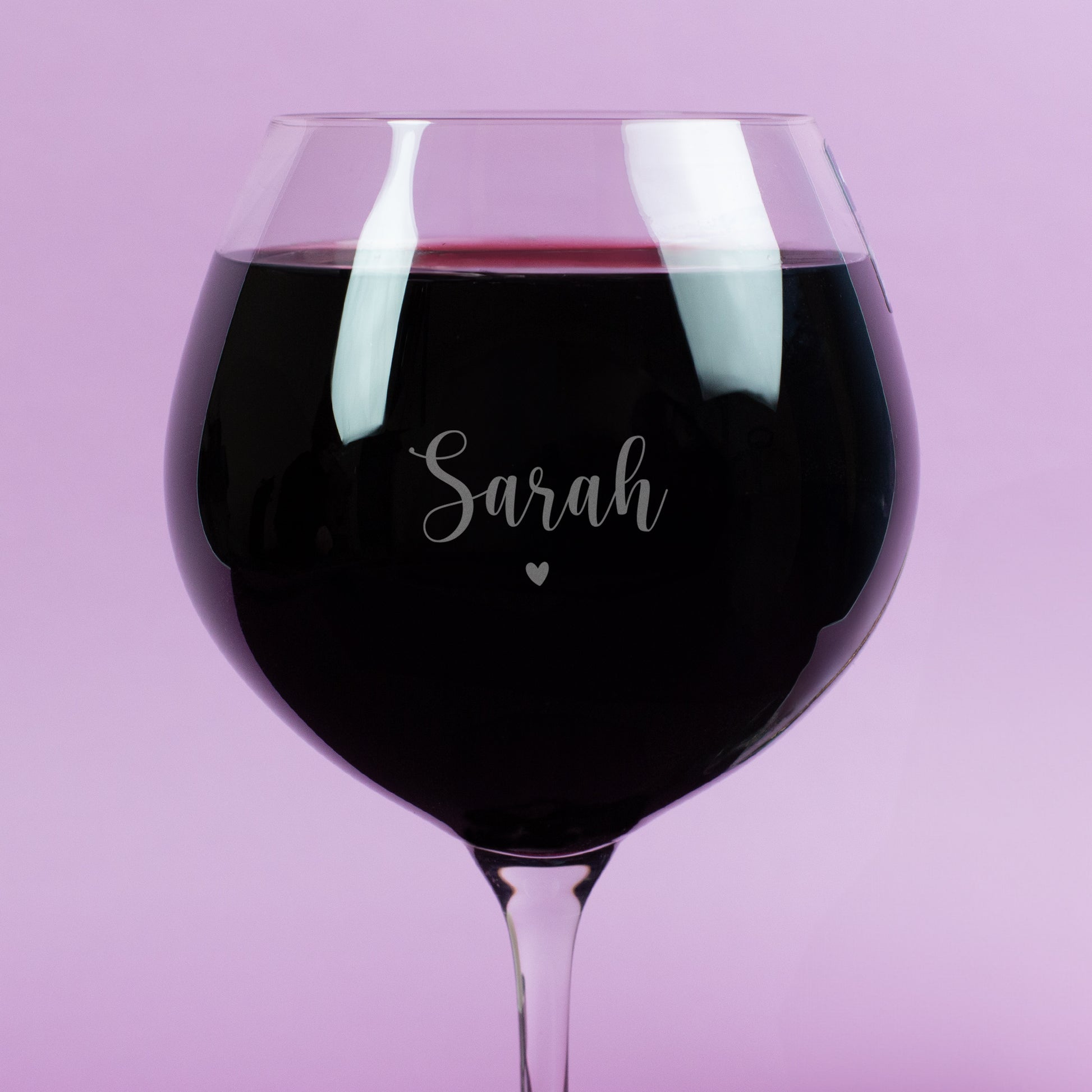Detailansicht der Gravur auf Burgunderglas – Name „Sarah“ mit zartem Herzsymbol, feine Gravur auf klarem Glas, Rotwein betont Schriftzug, romantisches Design.