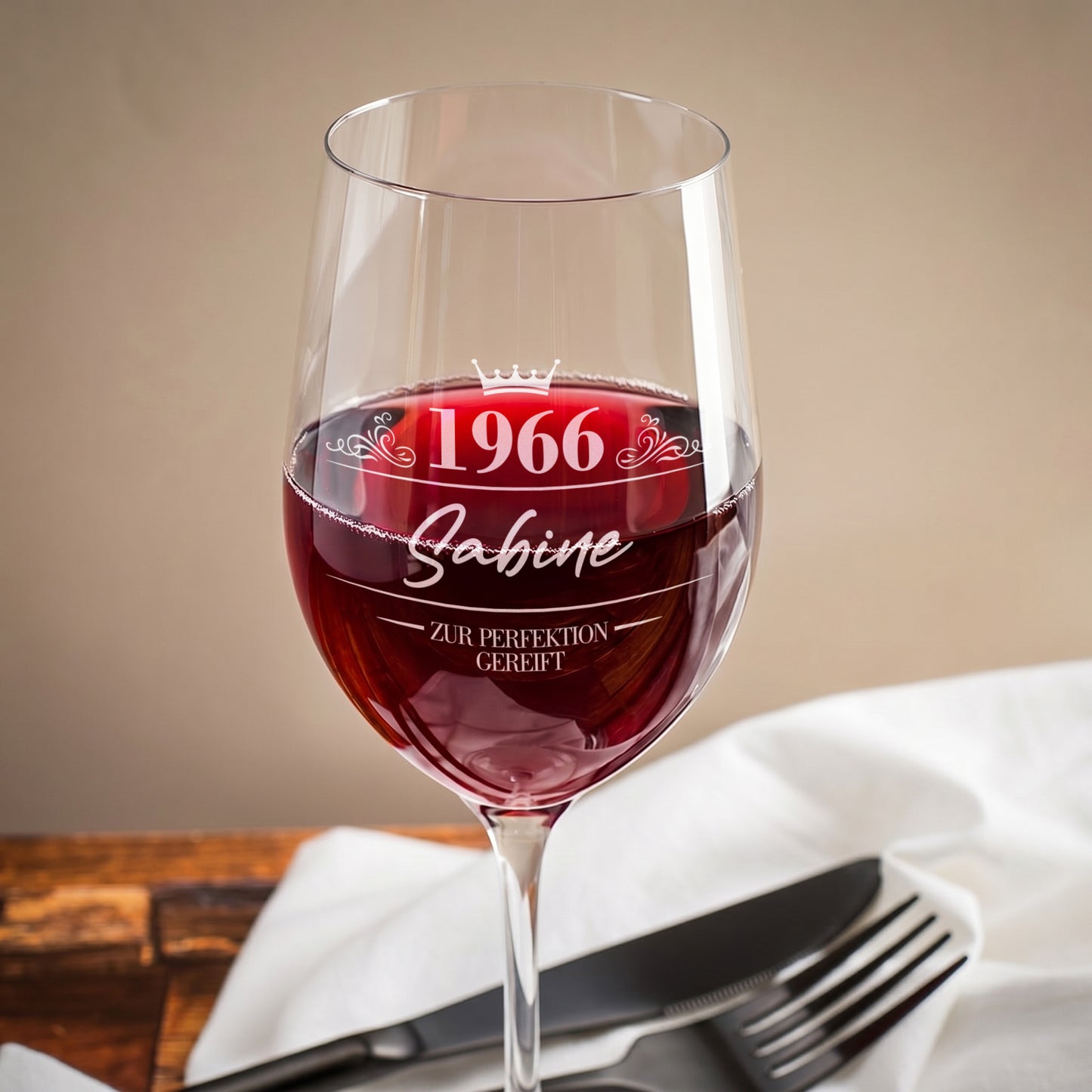 Nahaufnahme eines Leonardo Weinglases mit Gravur „1966 Sabine – Zur Perfektion gereift“ auf einem gedeckten Tisch