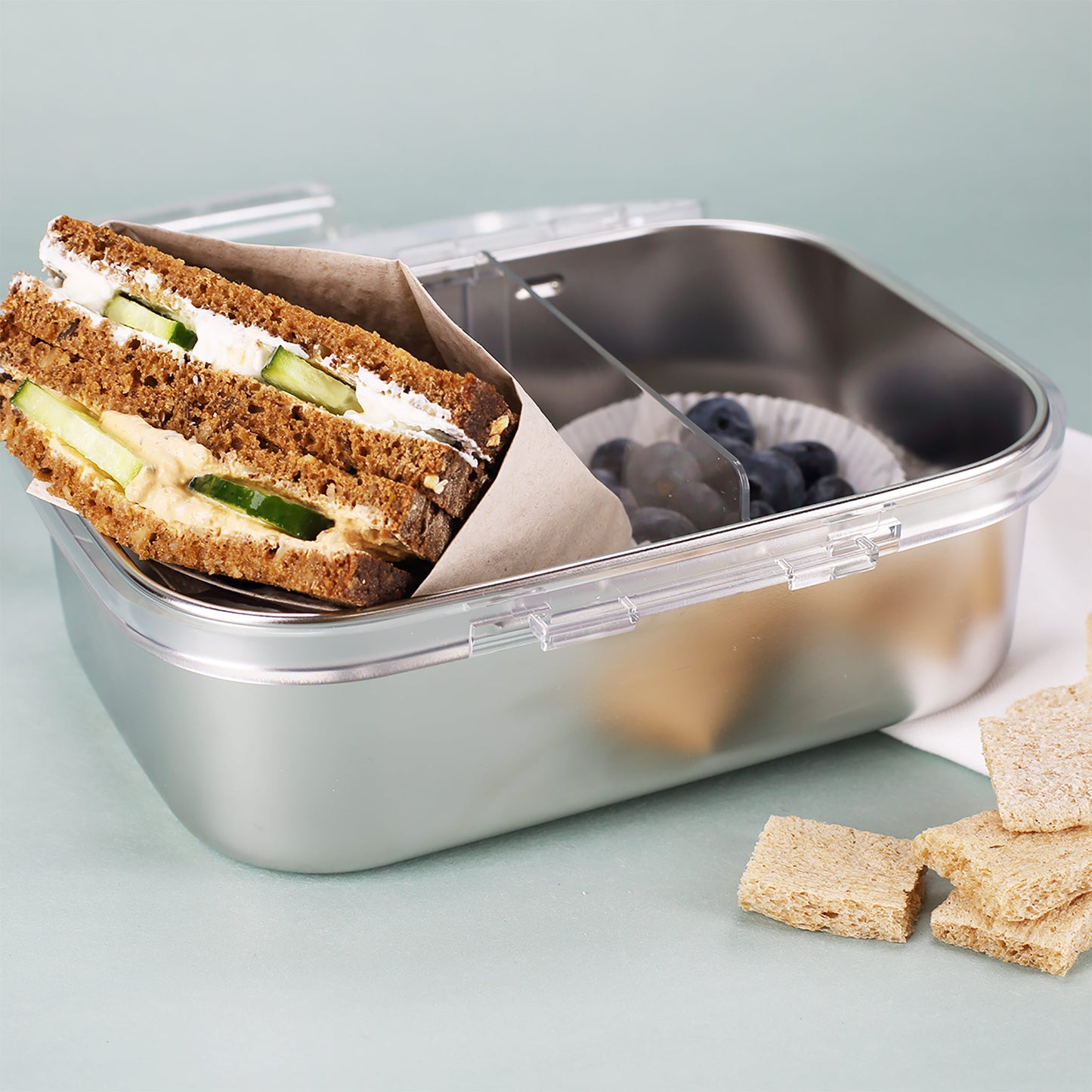 Geöffnete Brotdose mit belegtem Sandwich, Trennwand und Heidelbeeren