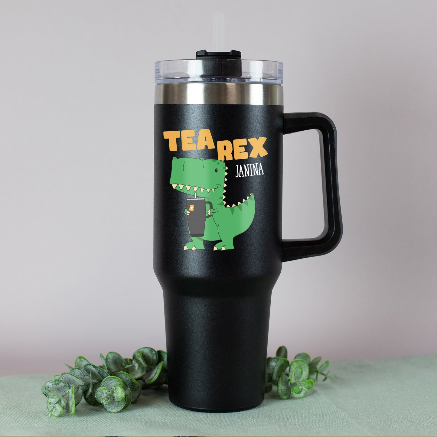 Detailansicht: T-Rex hält einen Becher, darüber der orangene Schriftzug