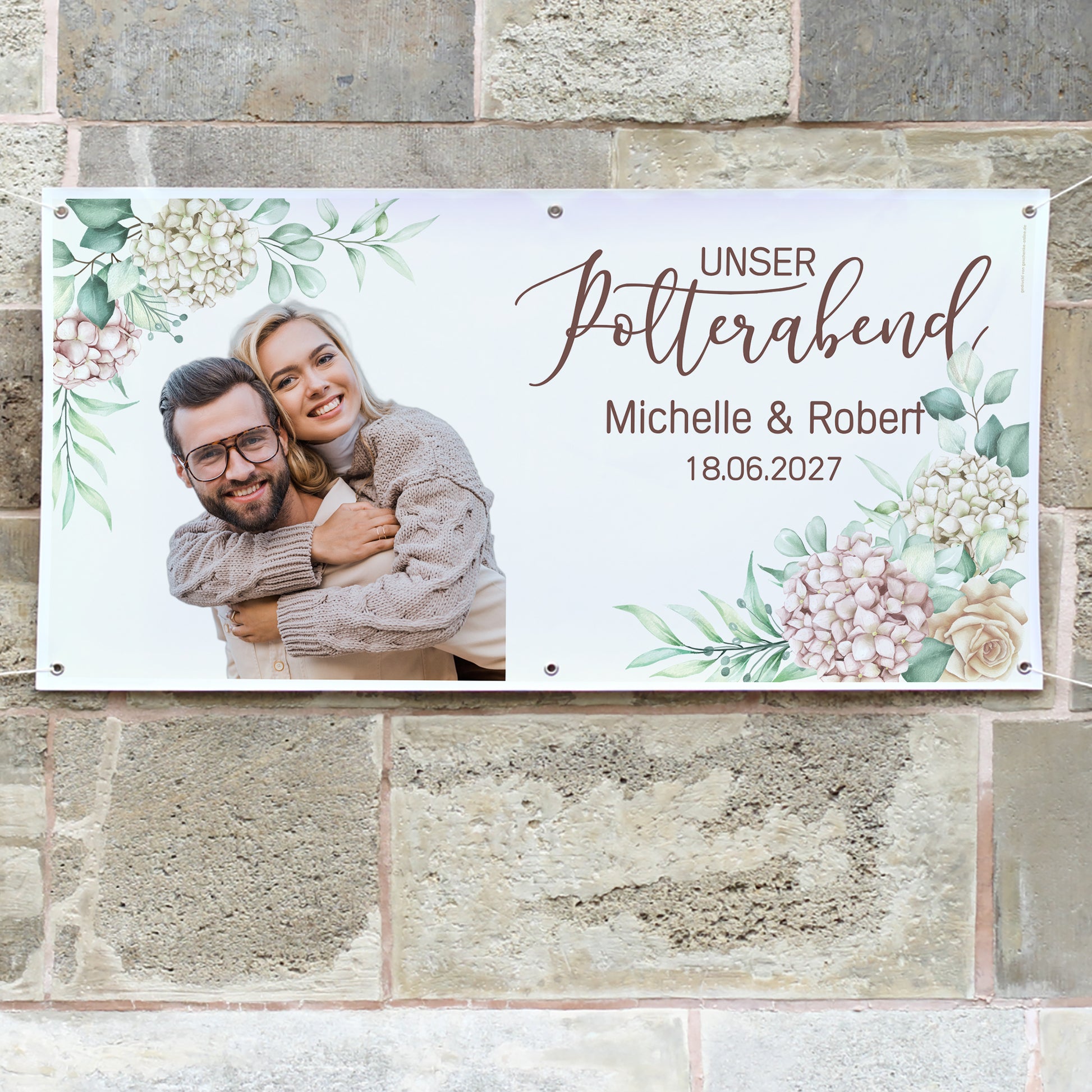 Personalisiertes Polterabend-Banner mit Michelle und Robert an einer Steinwand befestigt