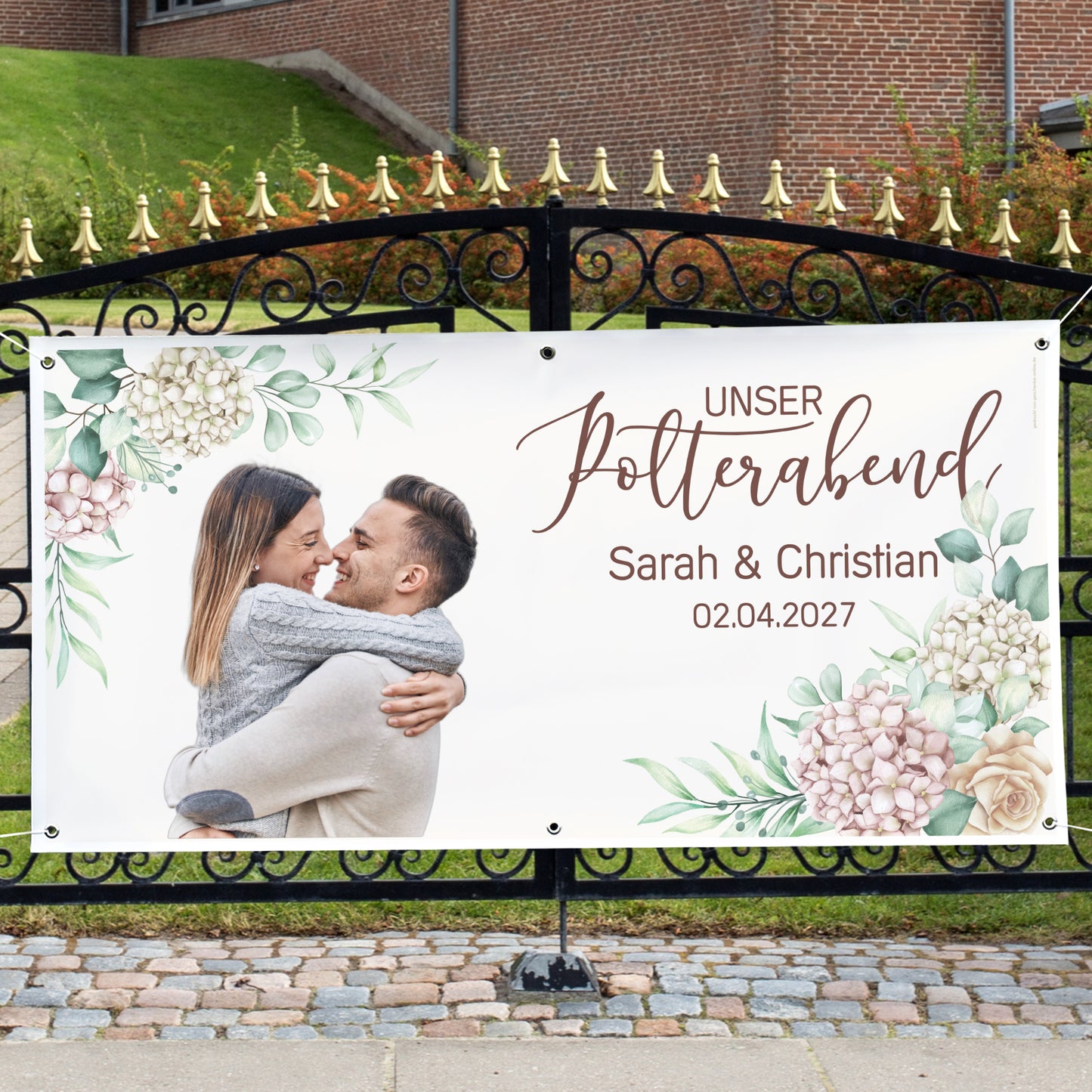 Großes Polterabend-Banner mit Foto, Namen Sarah und Christian und Blumenmotiv an einem Gartentor