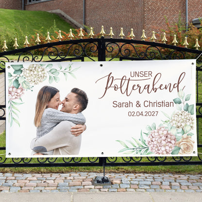 Großes Polterabend-Banner mit Foto, Namen Sarah und Christian und Blumenmotiv an einem Gartentor