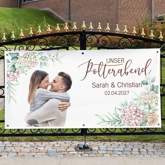 Großes Polterabend-Banner mit Foto, Namen Sarah und Christian und Blumenmotiv an einem Gartentor