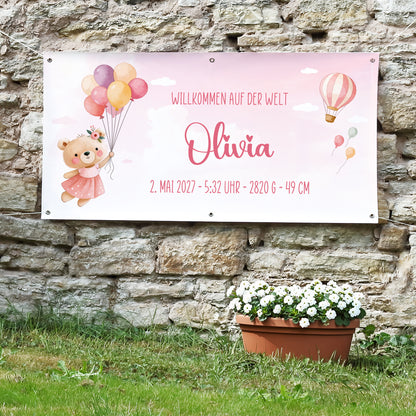 Personalisiertes Geburtsbanner für Mädchen mit Name Olivia, Geburtsdatum, Uhrzeit, Gewicht und Größe an Steinwand im Außenbereich