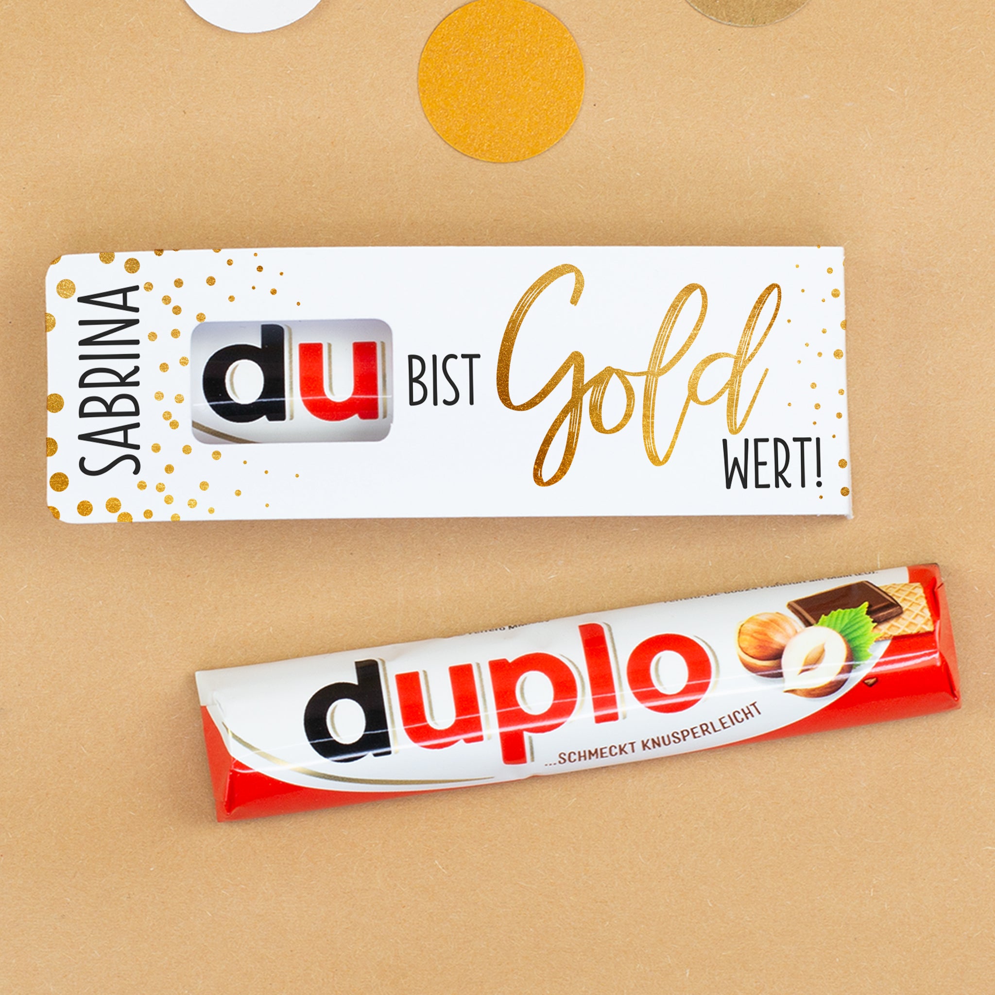 duplo Riegel mit personalisierter Verpackung auf dekoriertem Untergrund mit Konfetti
