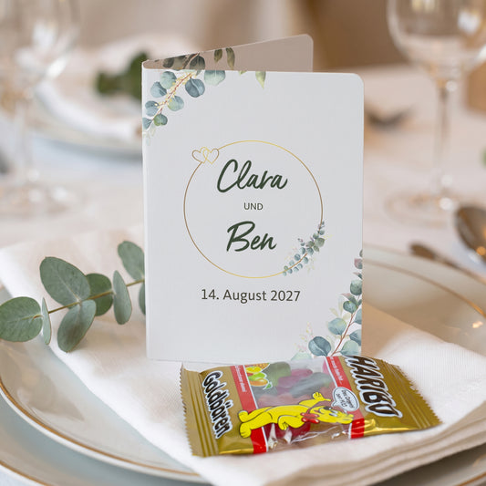 Personalisiertes Klappkärtchen zur Hochzeit mit Haribo Goldbären als Gastgeschenk auf gedecktem Teller