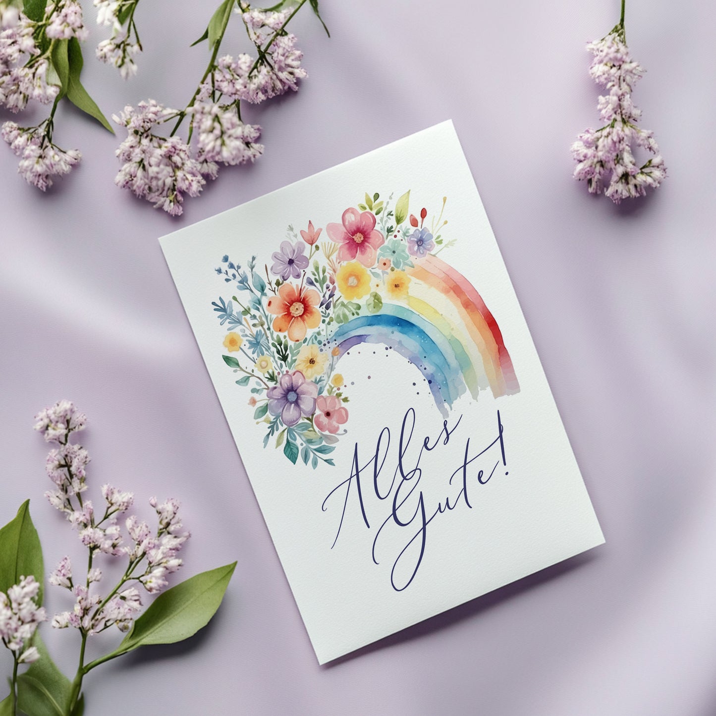 Glückwunschkarte mit Regenbogen, Blumen und Schriftzug Alles Gute auf hellem Hintergrund