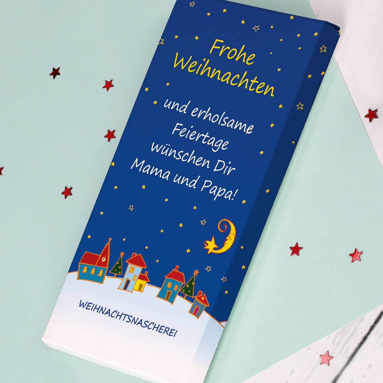 Farbenfrohe Schokolade zu Weihnachten mit Dorf im Schnee und Ihrem Text