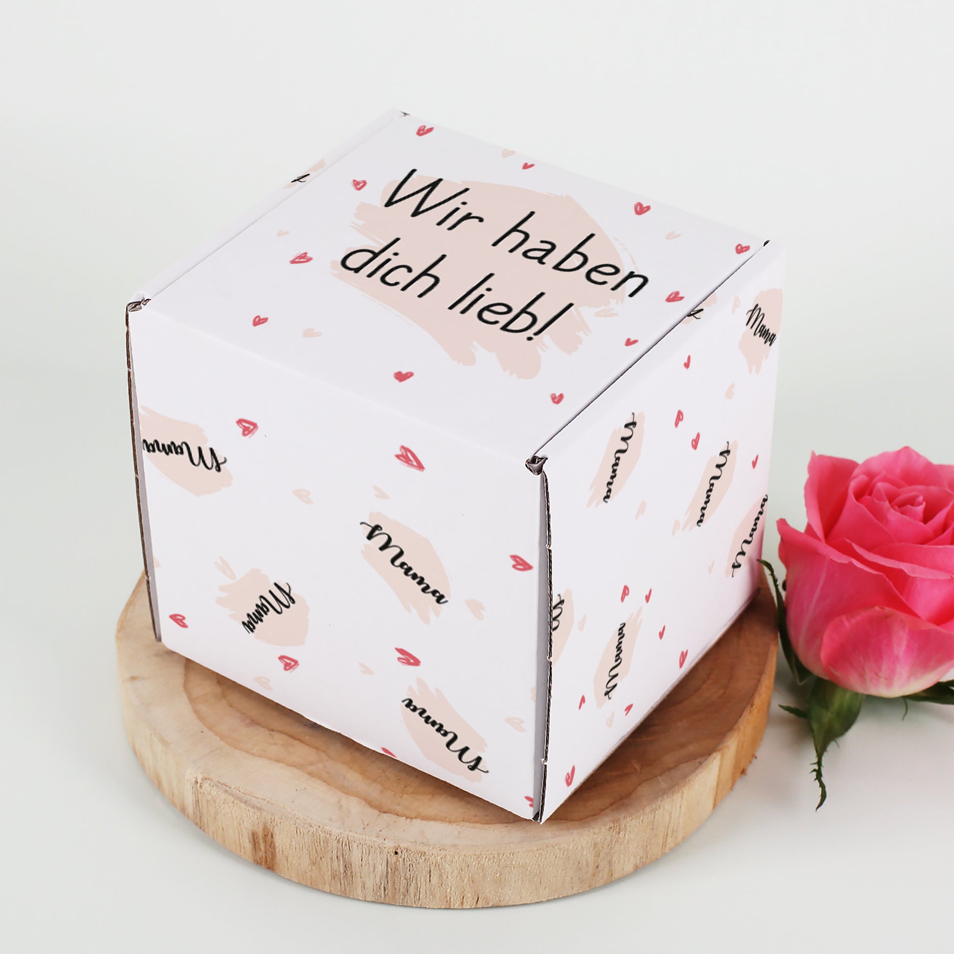 Geschenkbox mit Herz-Motiv personalisiert mit Name & Wunschtext auf einer Baumscheibe seitlich fotografiert.