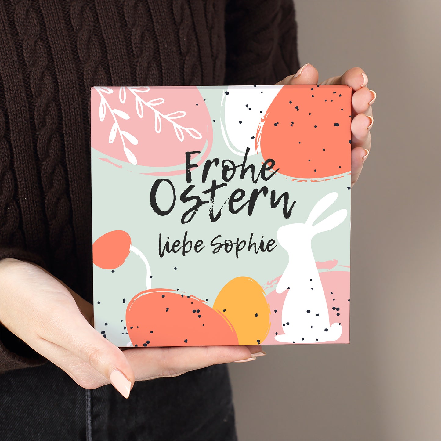 Personalisierte Lindt Oster-Pralinenbox mit Aufdruck „Frohe Ostern“ und Name liebe Sophie in der Hand gehalten