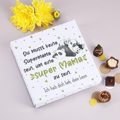 Pralinenschachtel Super Mama Panda mit Wunschtext neben gelber Blume und Pralinen