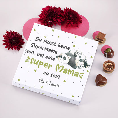 Lindt Pralinen Box Super Mama Panda mit roter Dekoration und Pralinen daneben