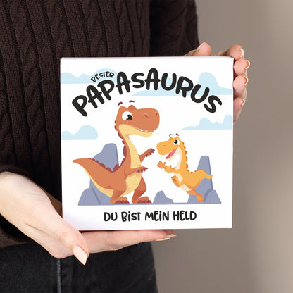Weiße Pralinenschachtel mit Dino Motiv „Bester Papasaurus“ und individuellem Text in der Hand gehalten