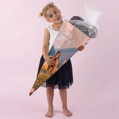 Mädchen mit personalisierter Schultüte mit Wildpferd-Motiv zur Einschulung