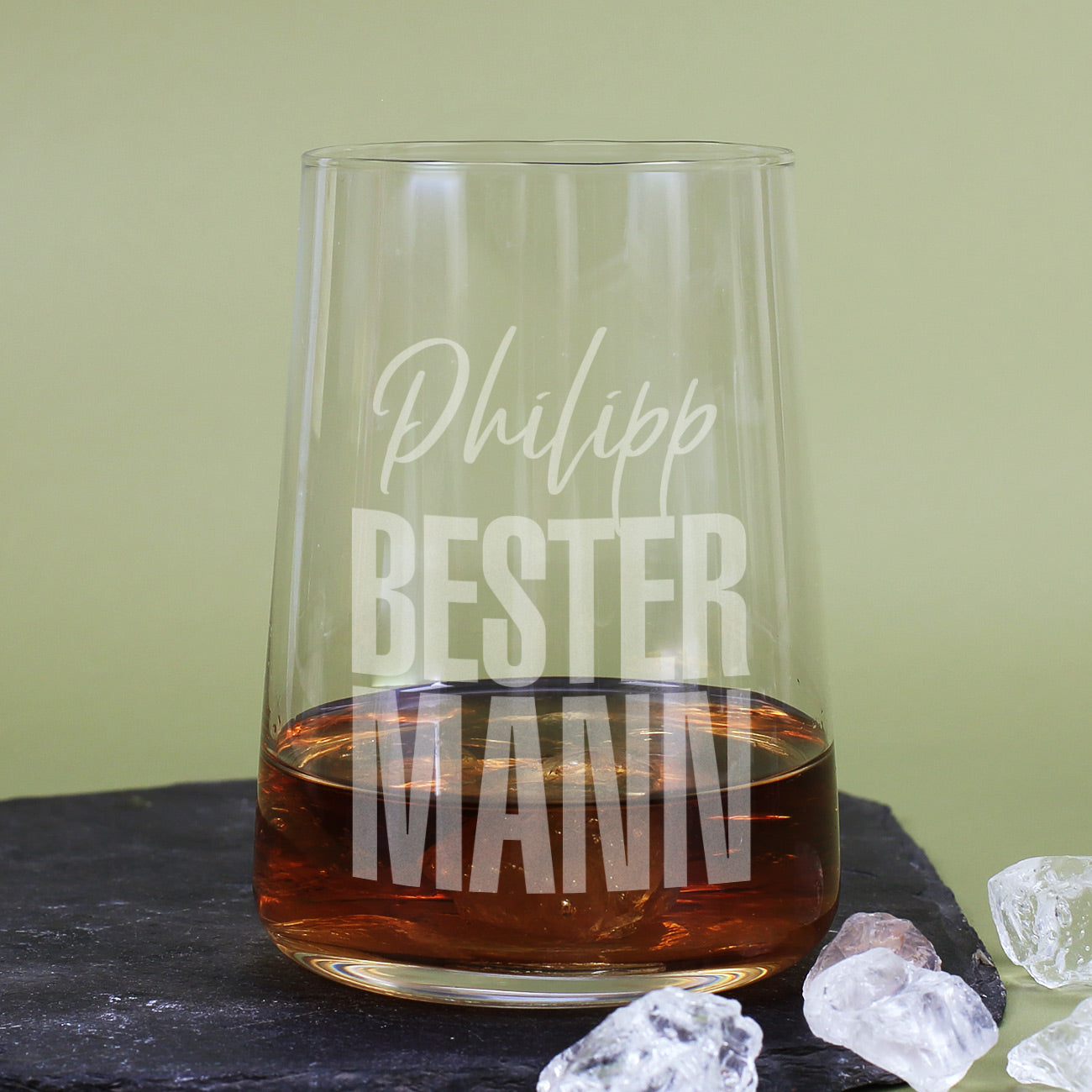 Trinkglas mit Gravur Bester Mann und Name mit dunklem Getränk auf Steinplatte
