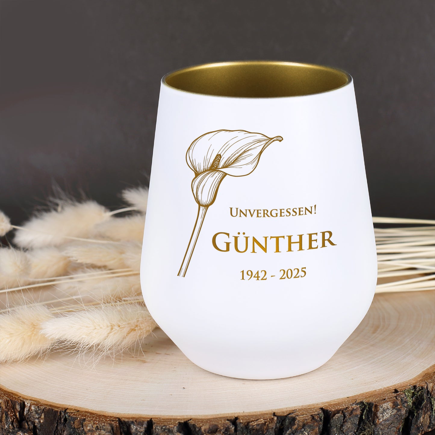 Weißes Windlicht mit Calla-Motiv, graviert mit "Unvergessen! Günther 1942–2025", auf Holzscheibe mit Trockenblumen