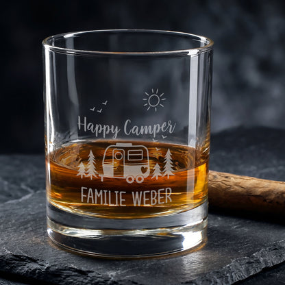 Whiskeyglas mit Camping-Gravur Happy Camper und Wunschtext Familie Weber auf dunklem Untergrund