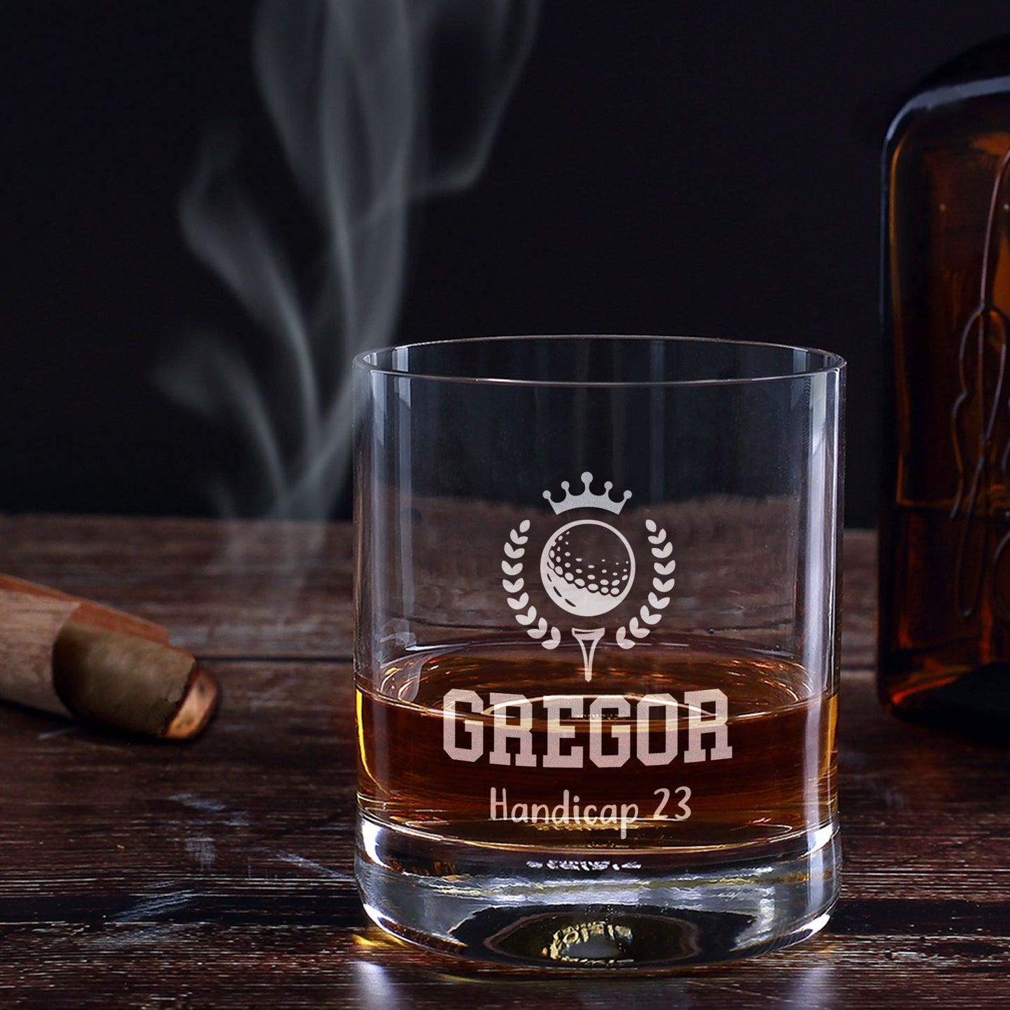 Personalisiertes Whiskeyglas mit Golfgravur, Name Gregor und Wunschtext Handicap 23 auf dunklem Holztisch