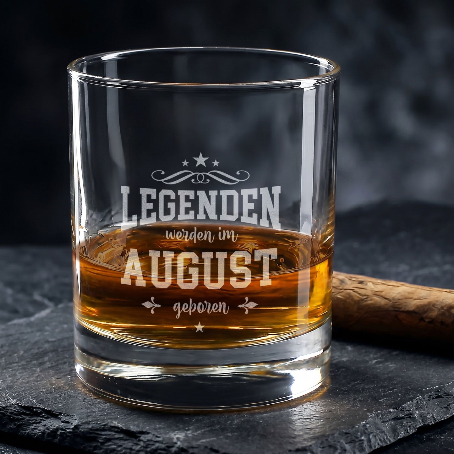 Graviertes Whiskyglas mit Spruch Legenden werden im August geboren auf dunklem Steinuntergrund