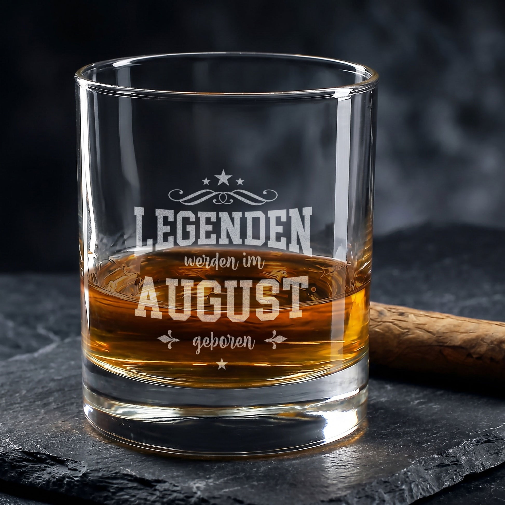 Graviertes Whiskyglas mit Spruch Legenden werden im August geboren auf dunklem Steinuntergrund