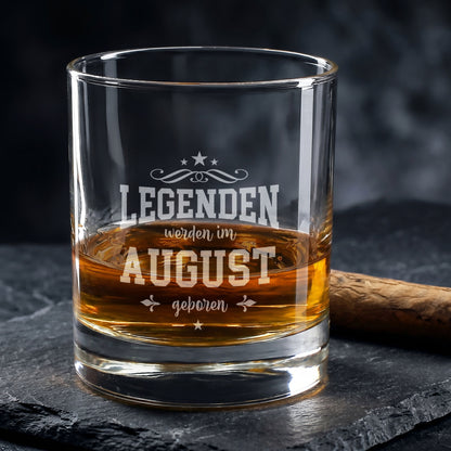 Graviertes Whiskyglas mit Spruch Legenden werden im August geboren auf dunklem Steinuntergrund
