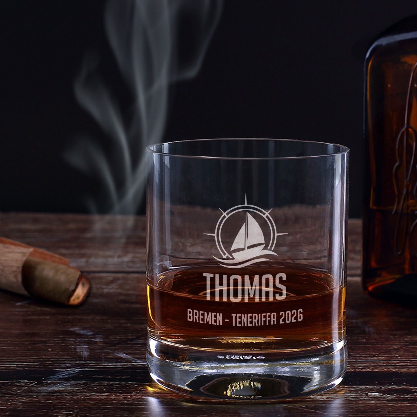 Whiskeyglas mit Segelboot-Gravur, Name Thomas und Wunschtext Bremen Teneriffa 2026 auf dunklem Holztisch