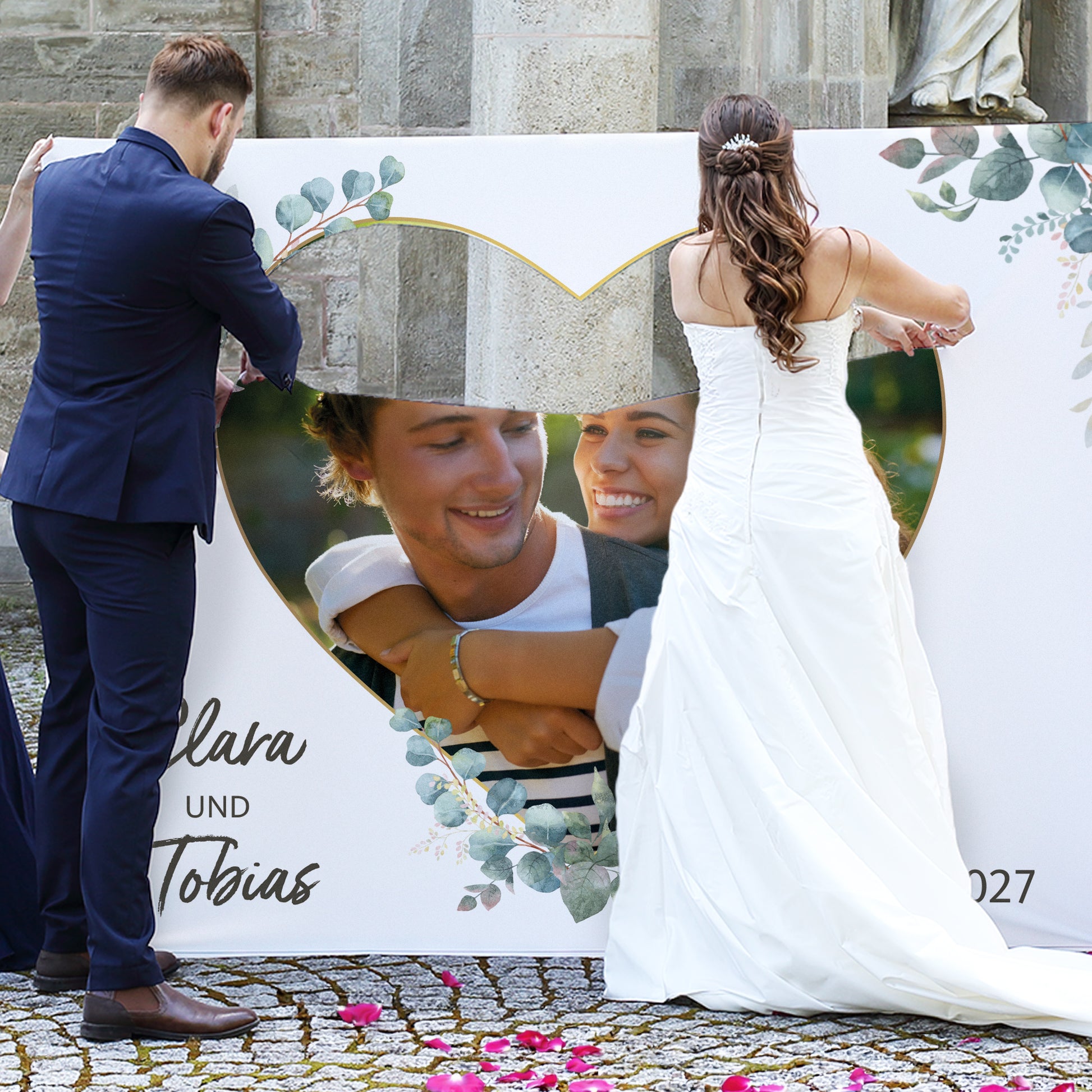 Brautpaar schneidet personalisiertes Hochzeitsbanner mit Foto, Namen Clara und Tobias und Hochzeitsdatum aus
