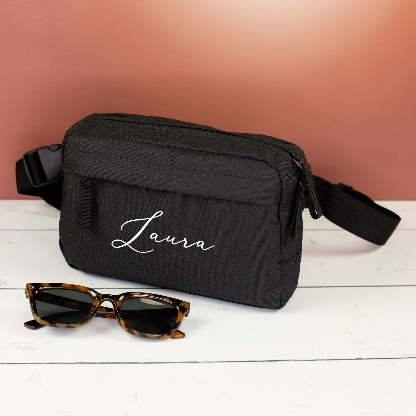 Schwarze Bauchtasche mit Name Laura als Geschenk für Frauen, dekoriert mit Sonnenbrille