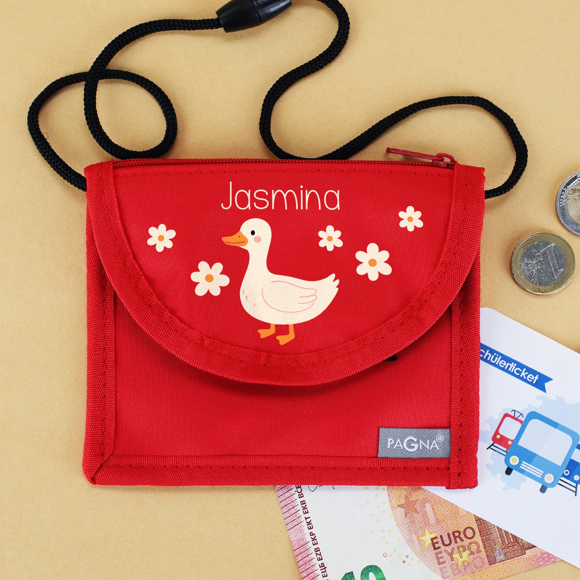 Roter Brustbeutel mit Name Jasmina, Ente und Blumen neben Geld und Schülerticket
