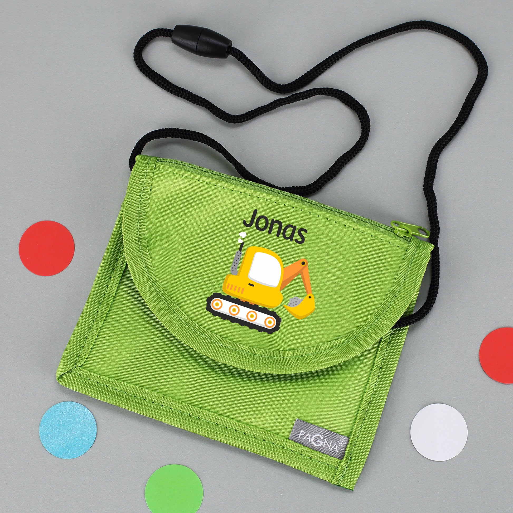 Grüner Brustbeutel mit Name Jonas und Bagger-Motiv auf grauem Hintergrund