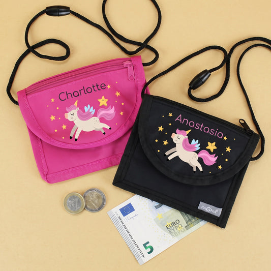 Pinker und schwarzer Brustbeutel mit personalisiertem Namen und Einhorn-Motiv, daneben Münzen und Geldschein als Beispiel für den Einsatz in Kindergarten und Schule.