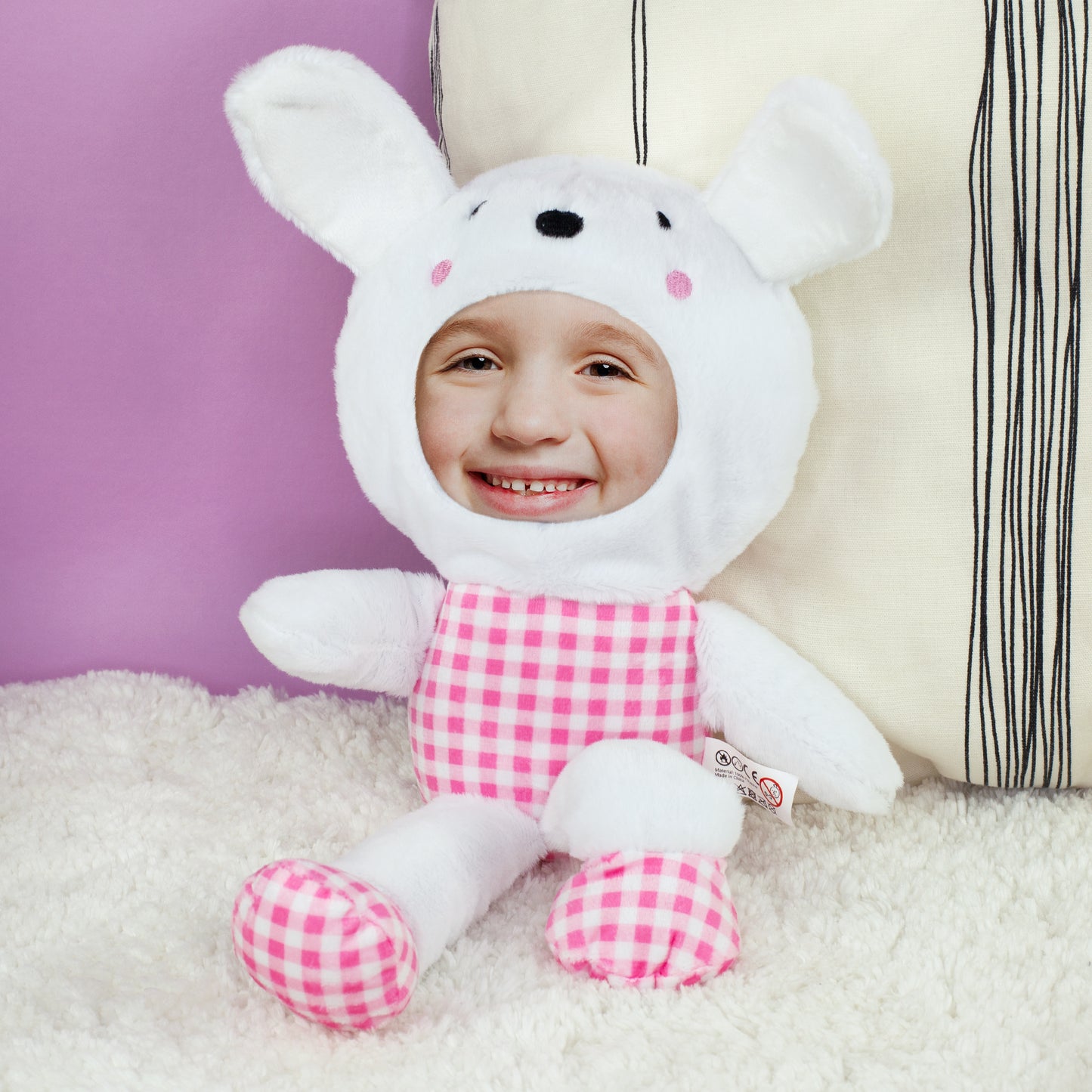 Personalisierter Fotohase mit rosa kariertem Outfit sitzend auf weicher Decke