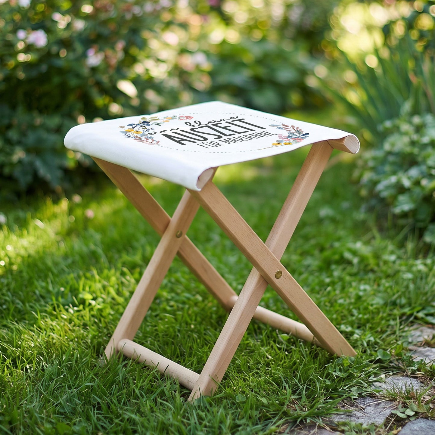 Klapphocker im Garten auf Rasen mit personalisiertem Aufdruck und Naturholzgestell