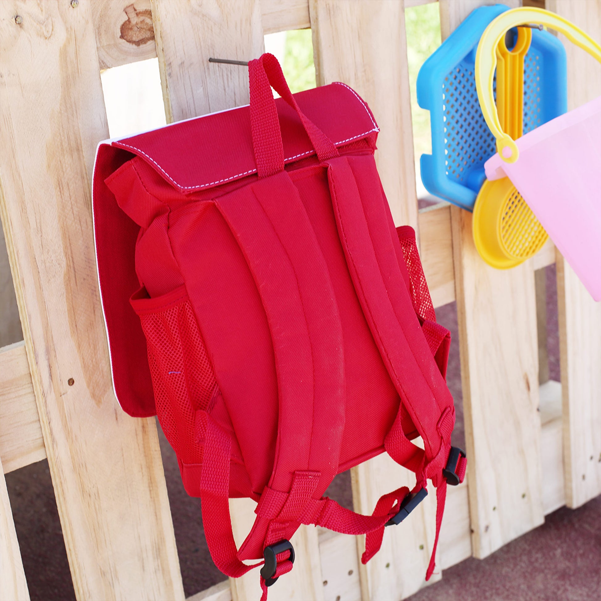 Rückansicht des roten Kindergartenrucksacks mit gepolsterten Trageriemen und Netzfächern