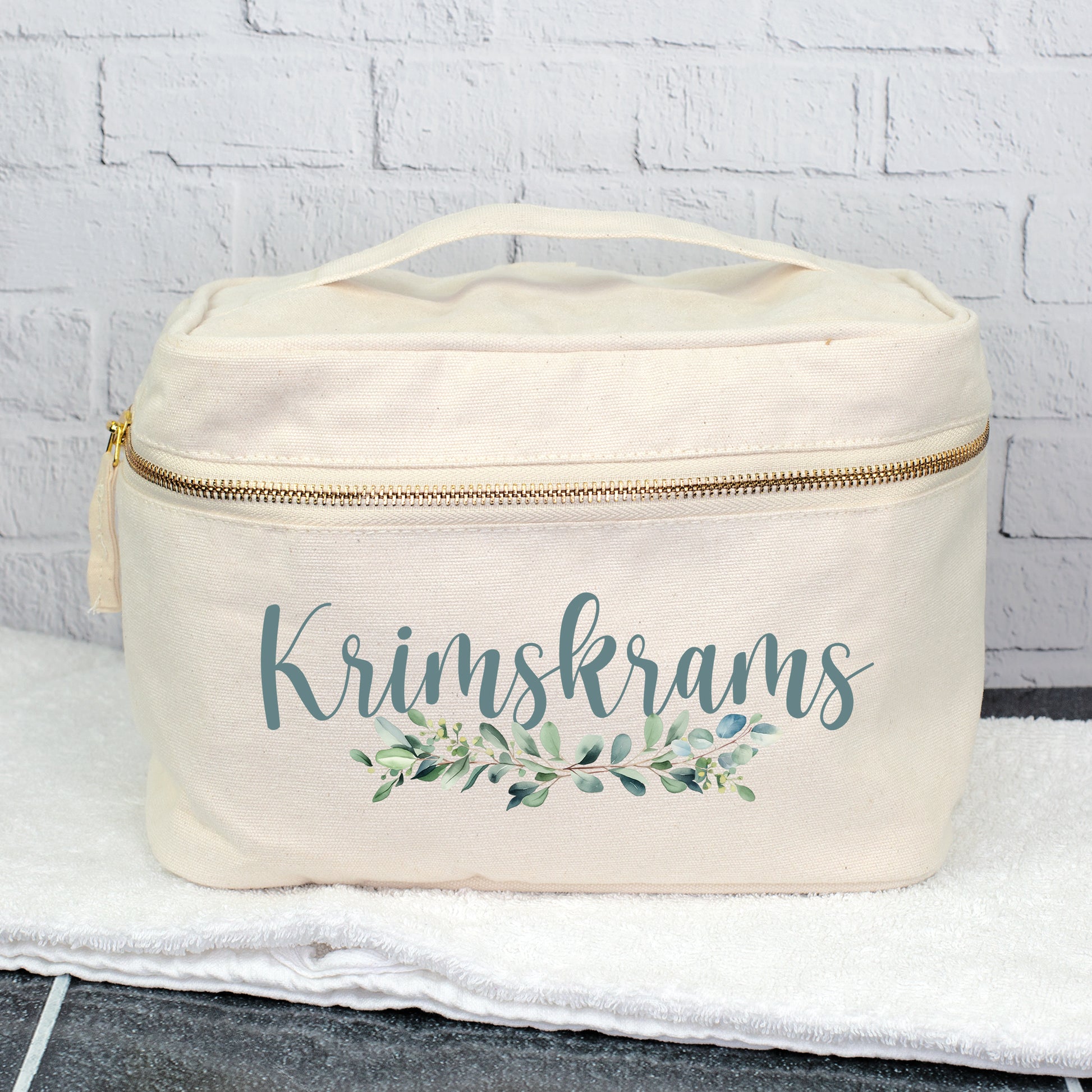 Personalisierter Kulturbeutel mit Aufdruck Krimskrams und Eukalyptus-Motiv auf einem Handtuch