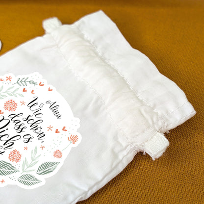 Nahaufnahme des Zugbands am bedruckten Geschenksäckchen mit Blumenmotiv