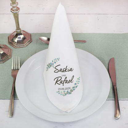 Personalisierte Stoffserviette mit Namen im Eukalyptus Design gefaltet auf gedecktem Hochzeitstisch