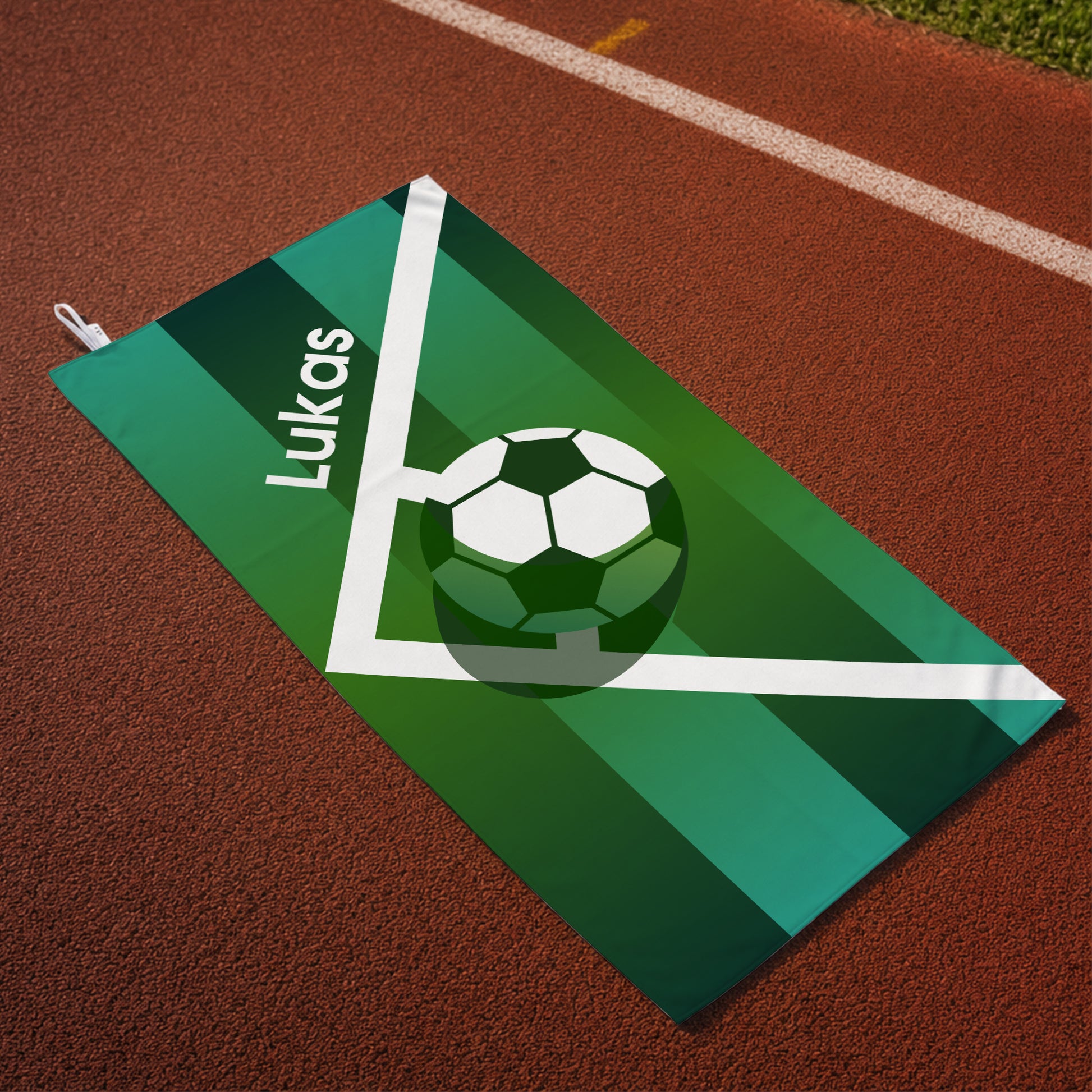 Personalisiertes Fußballhandtuch mit Name Lukas auf Sportplatz mit Spielfeldlinien