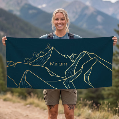 Person hält personalisiertes Sporthandtuch mit Bergmotiv und Name Miriam vor Bergkulisse