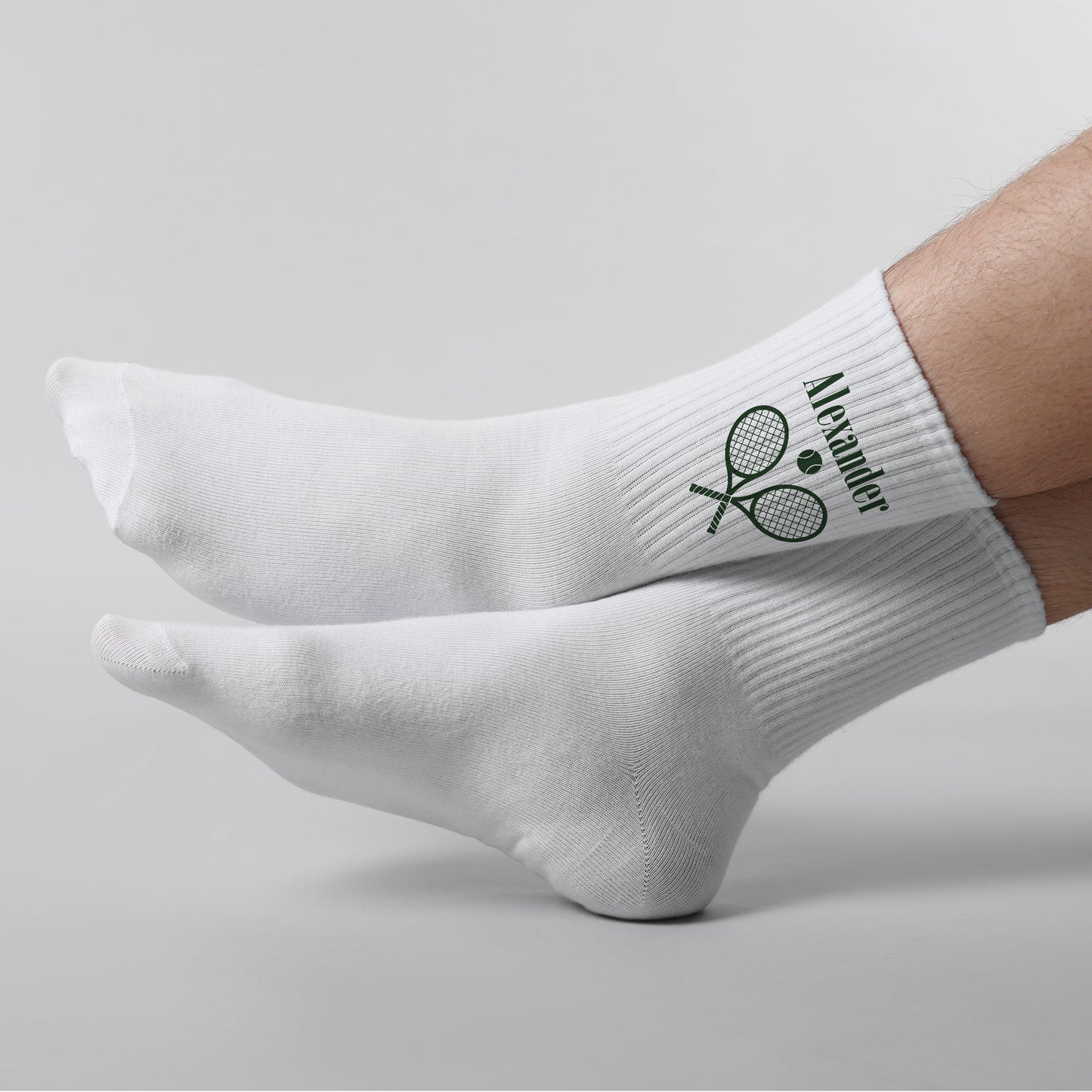 Weiße Tennissocken mit Name Alexander und Tennis-Motiv an ausgestreckten Füßen