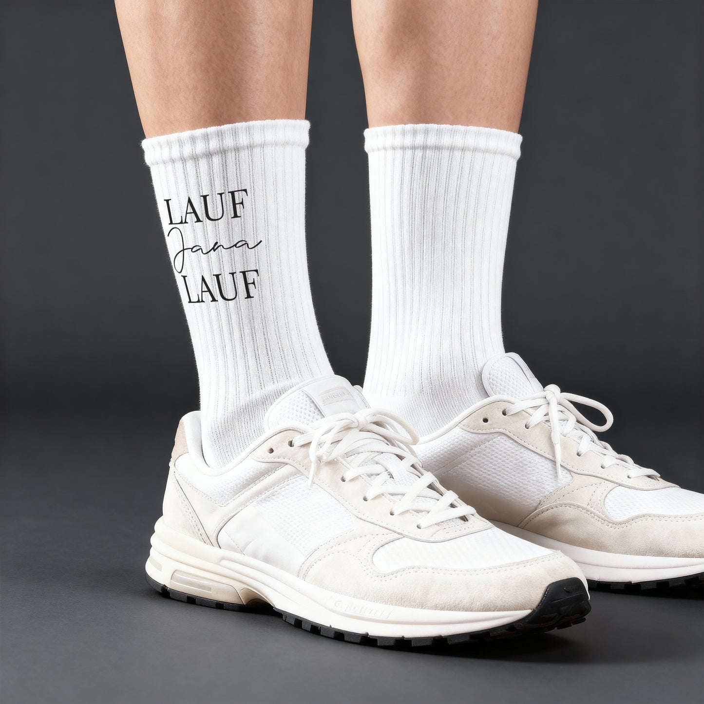 Person trägt weiße Sportsocken mit „Lauf Jana Lauf“-Aufdruck zu weißen Sneakern