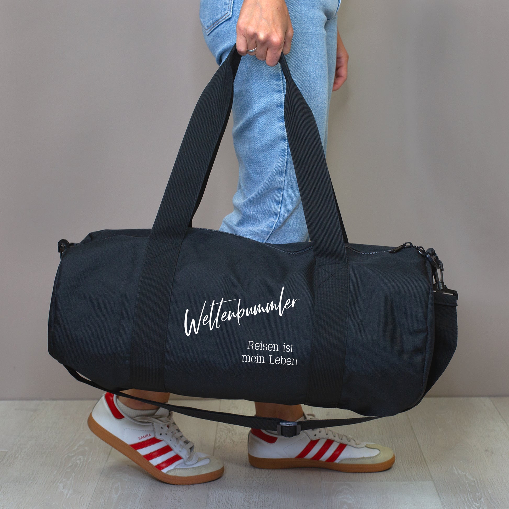 Schwarze XL Sporttasche mit Wunschtext, getragen als Trainingstasche.